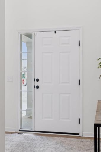 Insulated front entry door with full side light overlooking front porch.