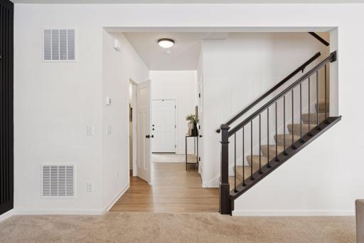 Open staircase railing and large 2 story foyer entry with ample natural light.