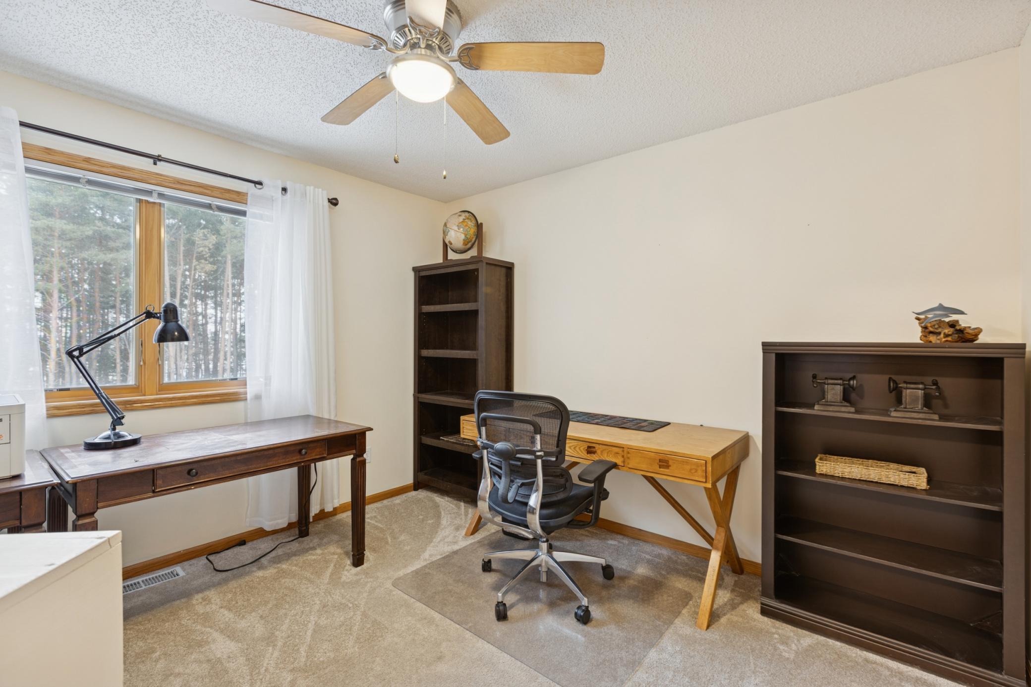 This upper-level bedroom enjoys wooded views and quiet surroundings.