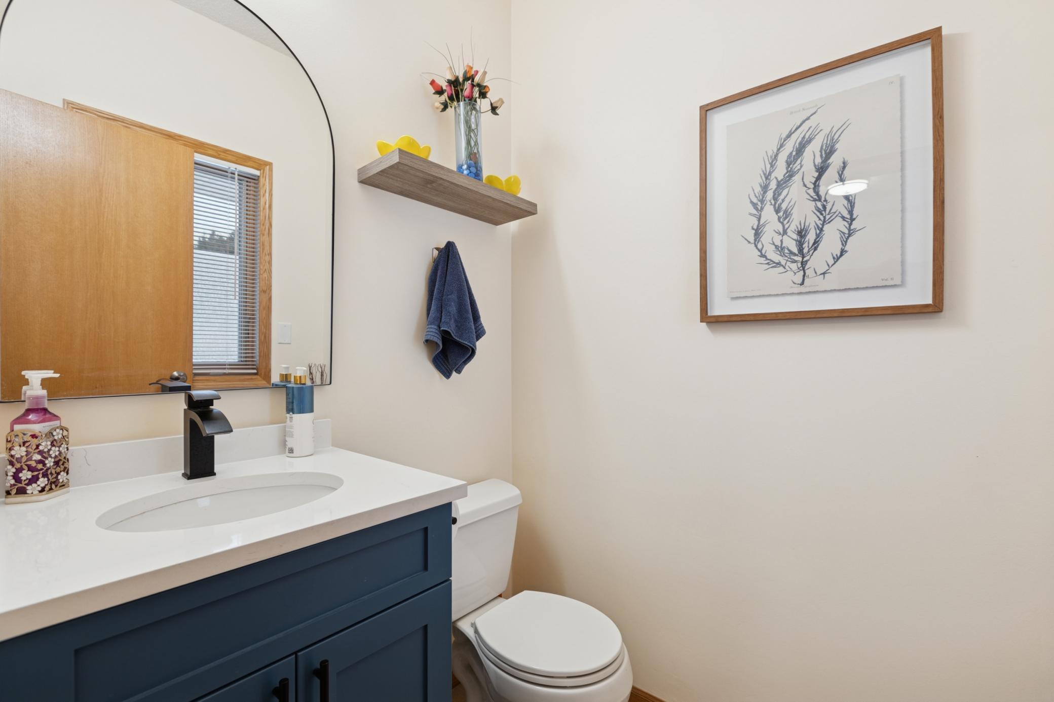 Half bath off kitchen/laundry with matching style and detail for cohesive design.