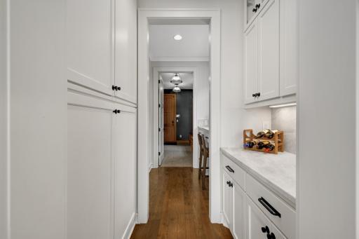 Thoughtfully designed pantry nook located between the kitchen and a resource area, offering ample pantry storage and countertop space. Ideal for organizing small appliances or a convenient staging area.