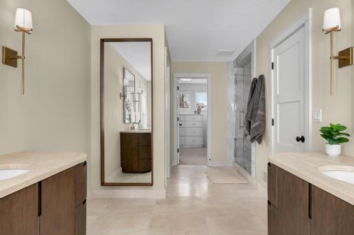 A neutral, modern primary bathroom where each area feels intentionally placed for privacy and ease of use. Every element feels organized, balanced and luxurious.
