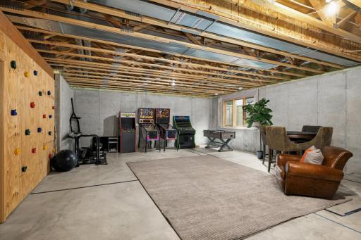 A great unfinished space, presently featuring a climbing wall and gaming area, with endless future potential.