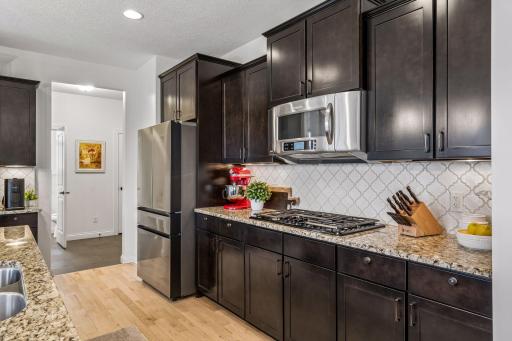 Gas range and built-in microwave with a clean tile backsplash for easy cooking and cleanup.