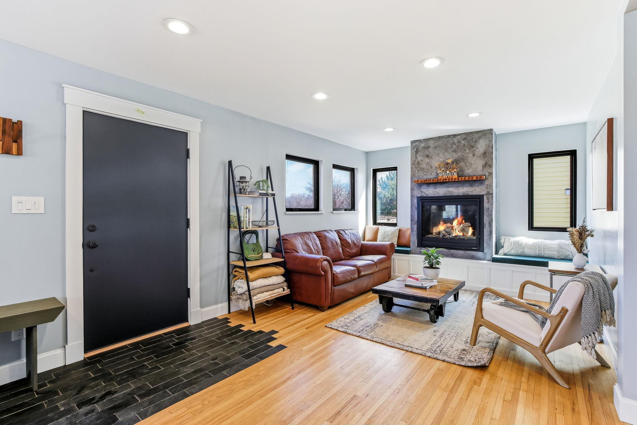 Bright living room with beautifully refinished hardwood floors and a modern gas fireplace centerpiece.