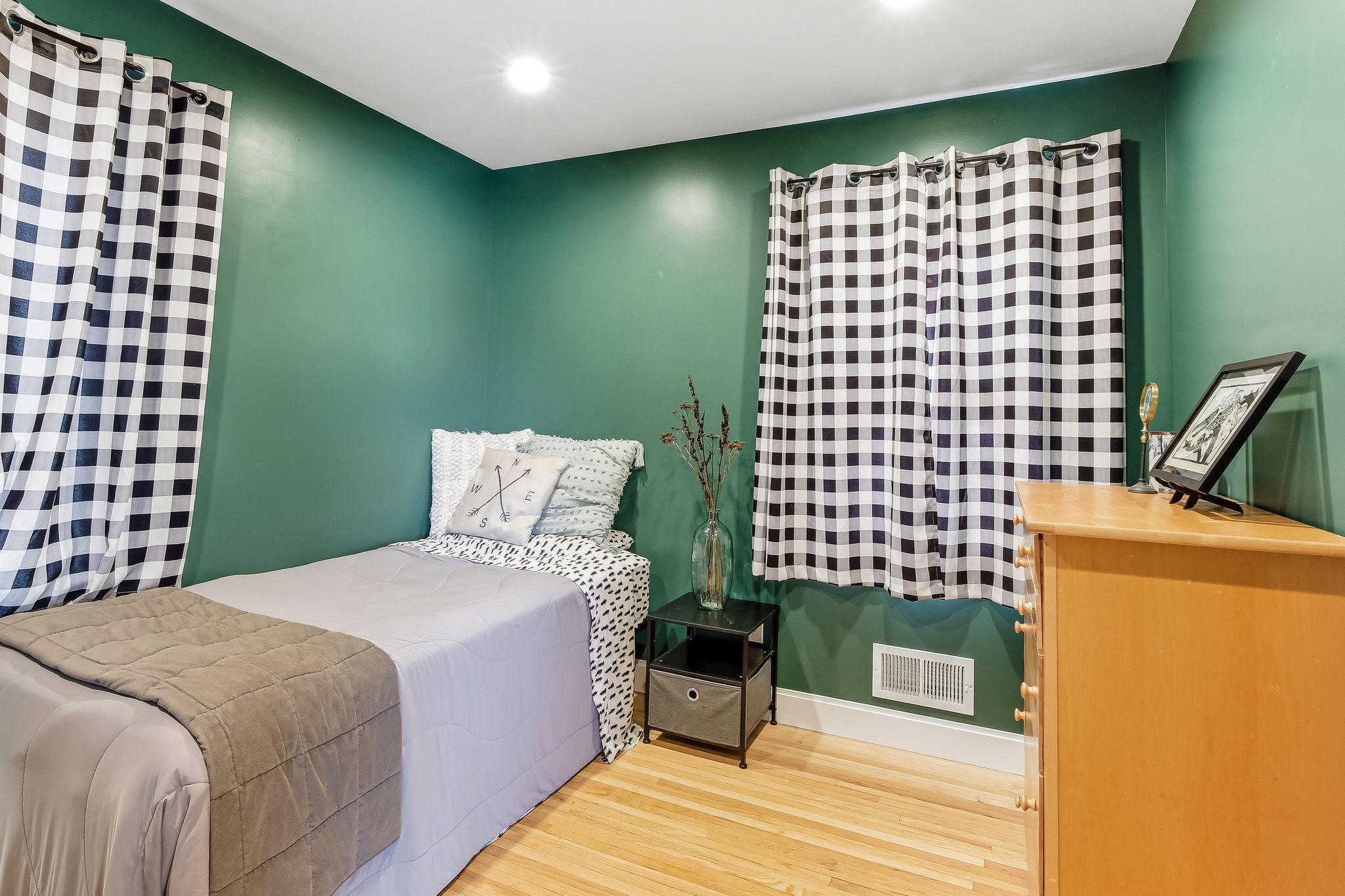 Main-level bedroom with beautiful hardwood floors—comfortable and inviting.