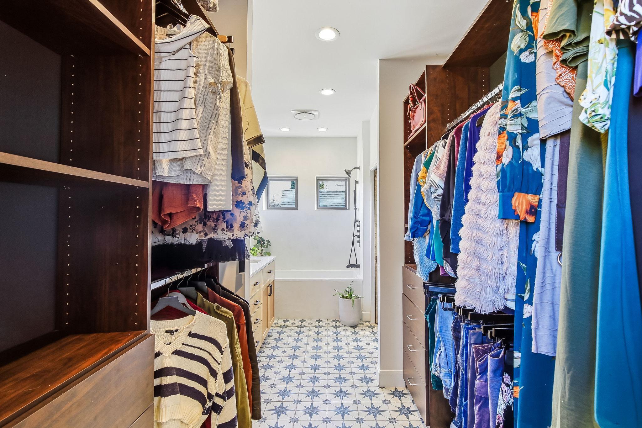 Spacious primary walk-through closet offering abundant storage, organization, and easy access to the en-suite bathroom.