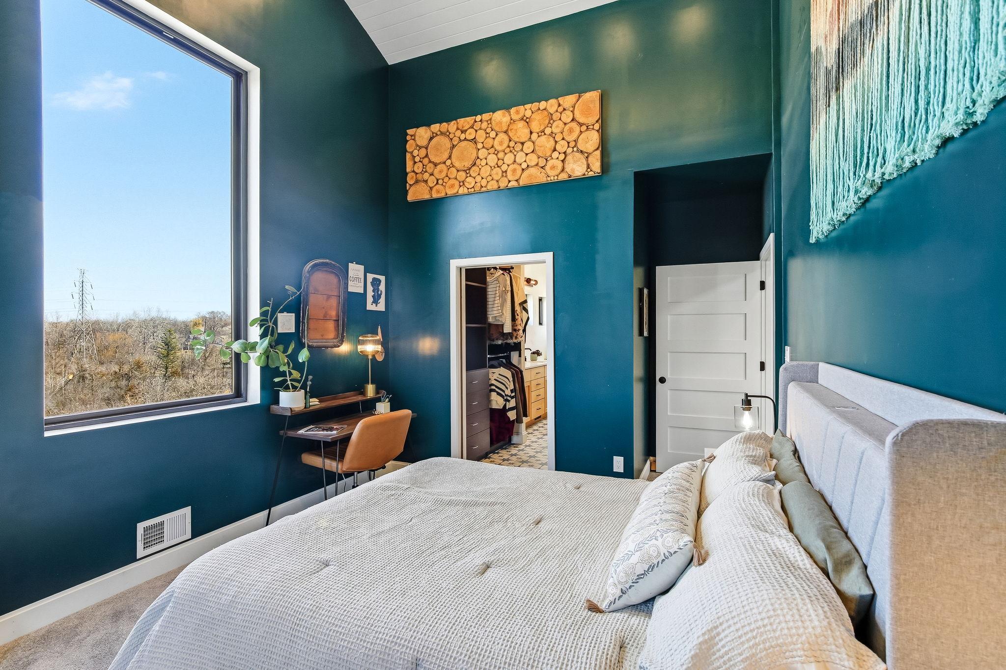 Primary suite with expansive window, offering light-filled comfort and picturesque views.