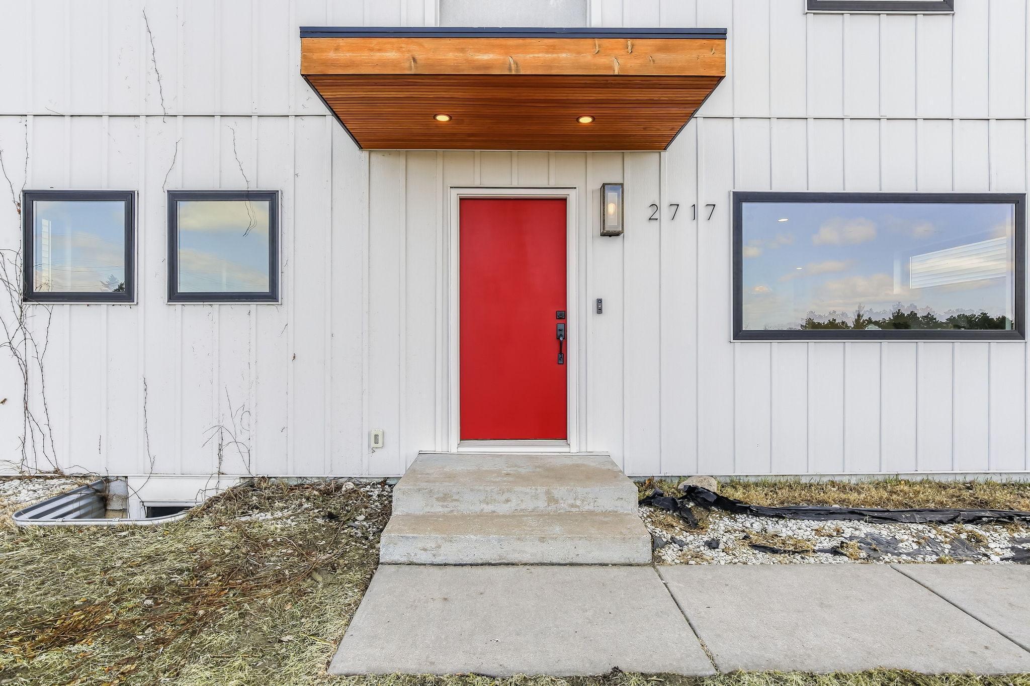 Striking red front door adds instant curb appeal and a welcoming touch