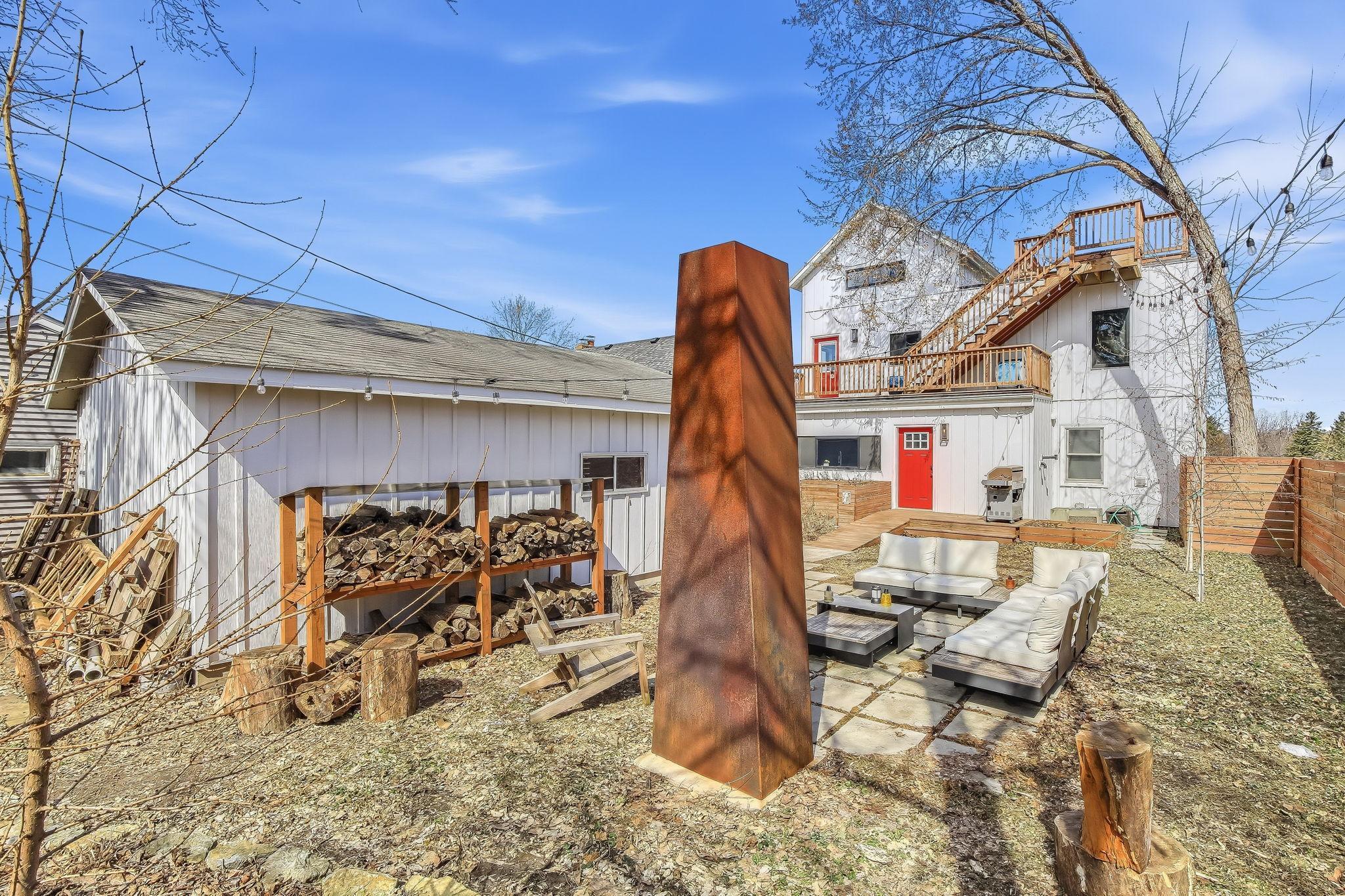 Low-maintenance outdoor area with no-mow lawn and a custom woodpile rack—perfect for easy care and cozy gatherings
