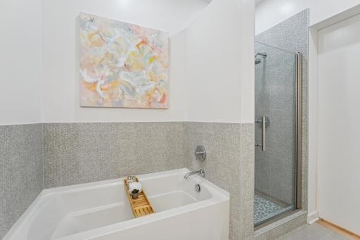 A deep soaking tub and glass-enclosed shower provide options for both rejuvenation and relaxation.