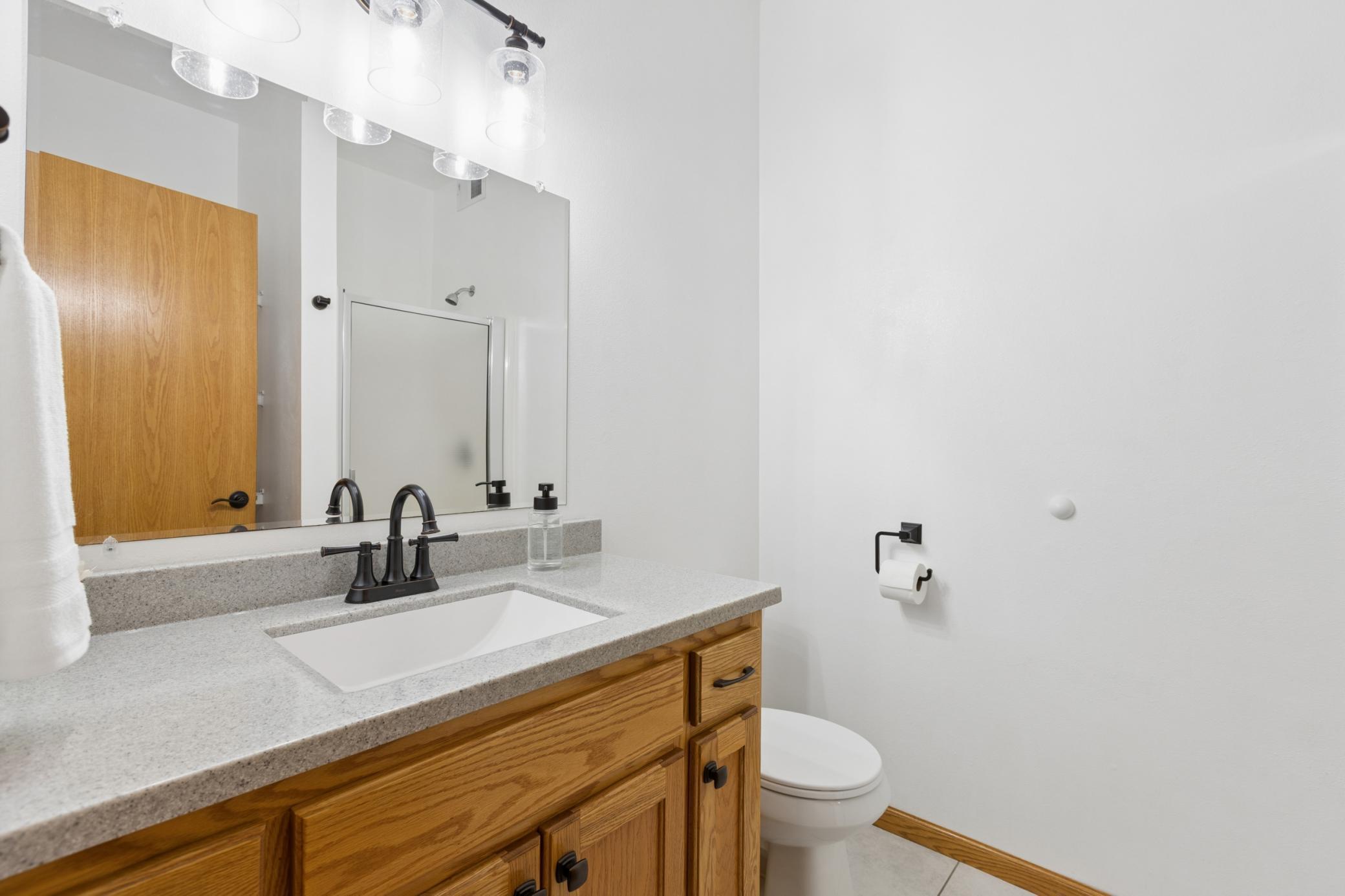 View of the lower level three quarter bath with tile floors. The in-floor heat runs throughout the home so your toes and never cold.