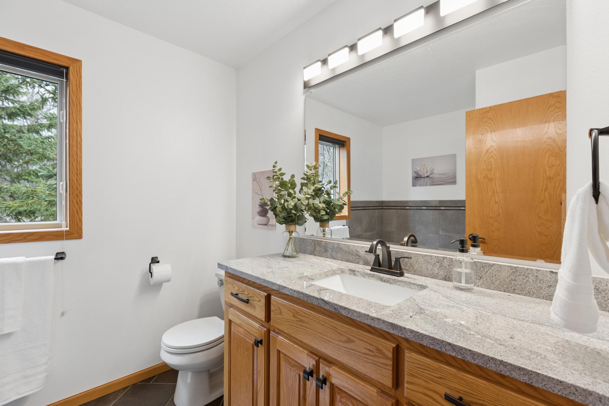 Just outside the bedroom is a beautiful bathroom with tile floors, upgraded countertops and a relaxing jetted soaking tub.