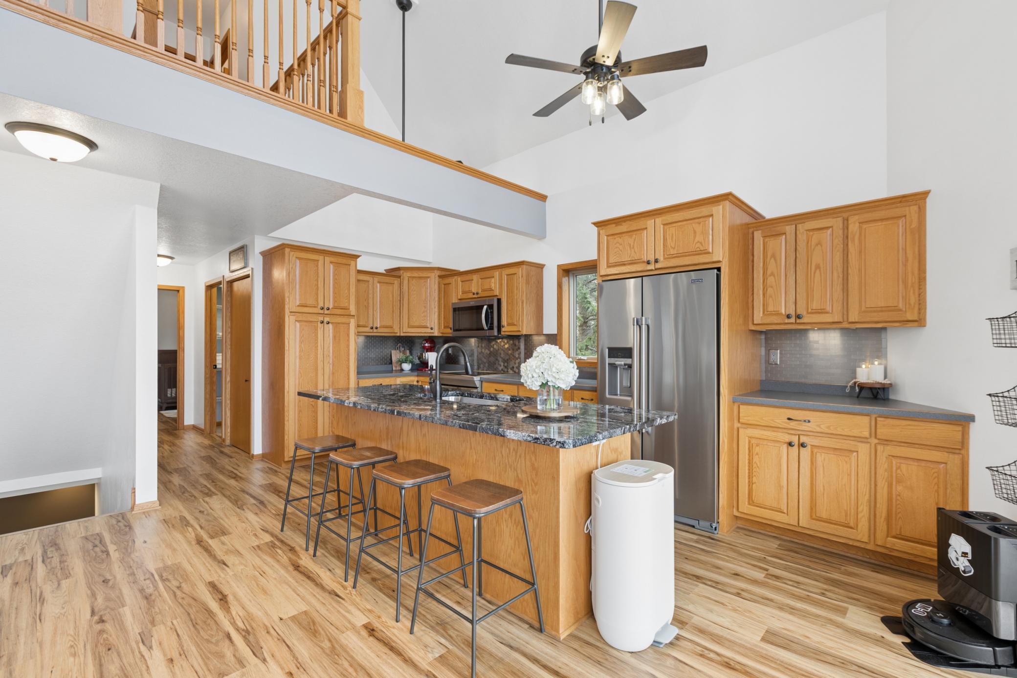The kitchen features a spacious center island with granite top providing plenty of prep space and storage. From the kitchen you can look out over the lake through the wall of windows to the South providing plenty of natural lighting.
