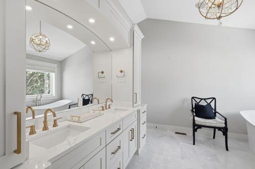 Primary ensuite bathroom has double vanity.