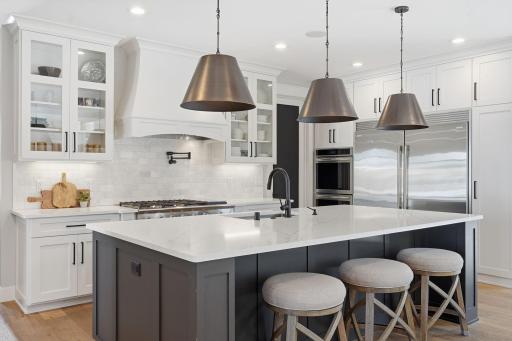 Gorgeous tiled backsplash accepts quartz countertops and cabinetry.