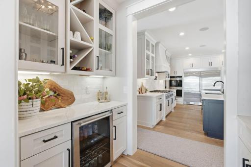 Serving area includes prep sink, cabinets and wine fridge.
