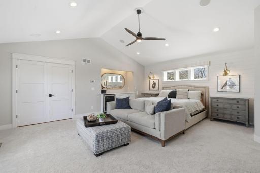 Primary suite includes vaulted ceilings, sitting area, fireplace and private balcony.