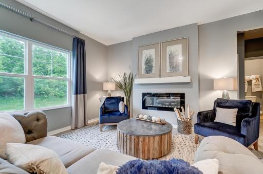 Large family room with electric fireplace creates a nice ambiance. Model picture shown. Colors and finishes may vary.