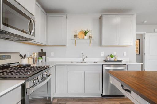 Stainless steel appliances and quartz countertops. Photo is of model home. Colors and options may vary. Ask Sales Agent for details.