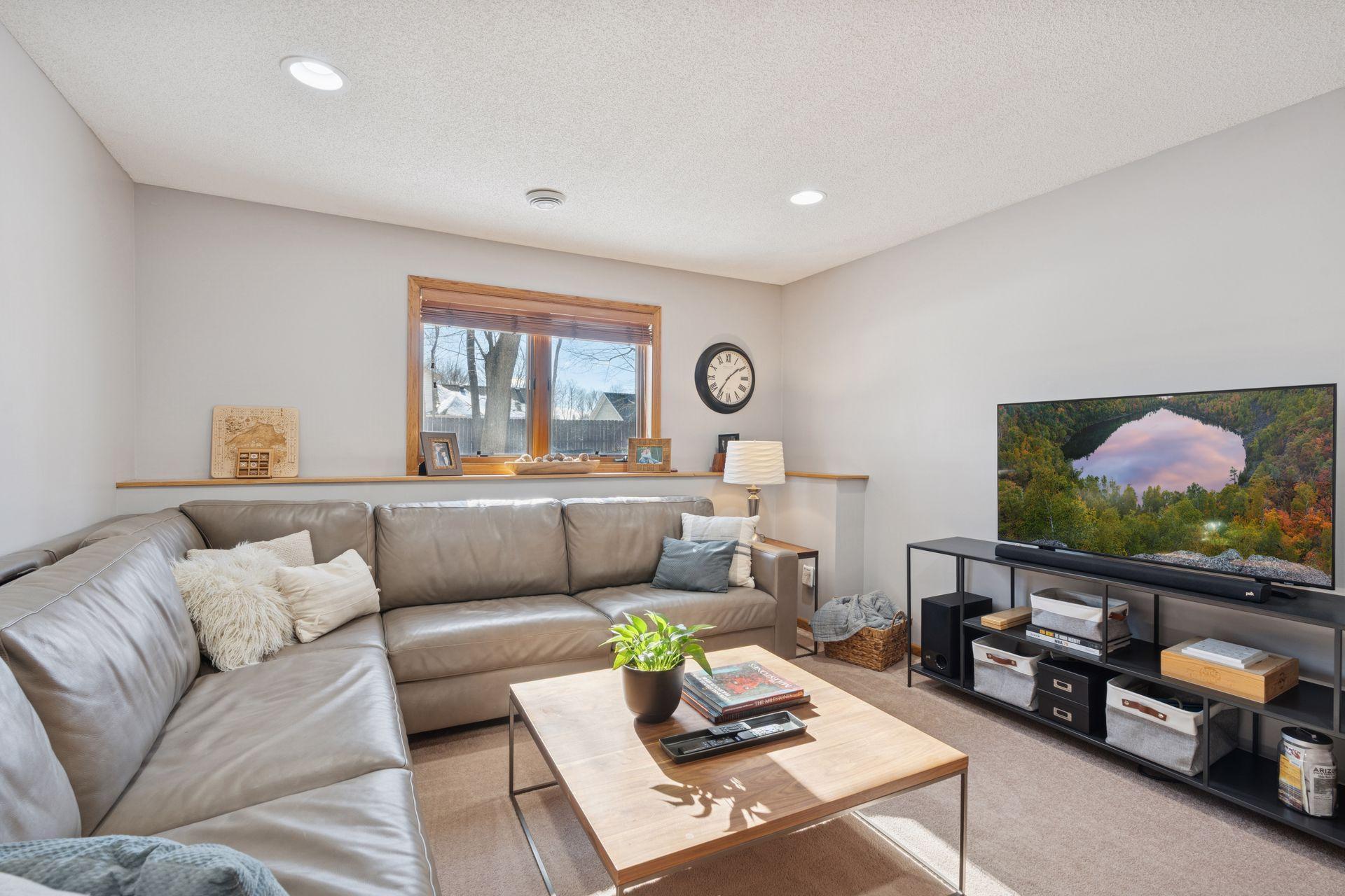 Lower level family room w/ a large window and a great space for family movie nights.