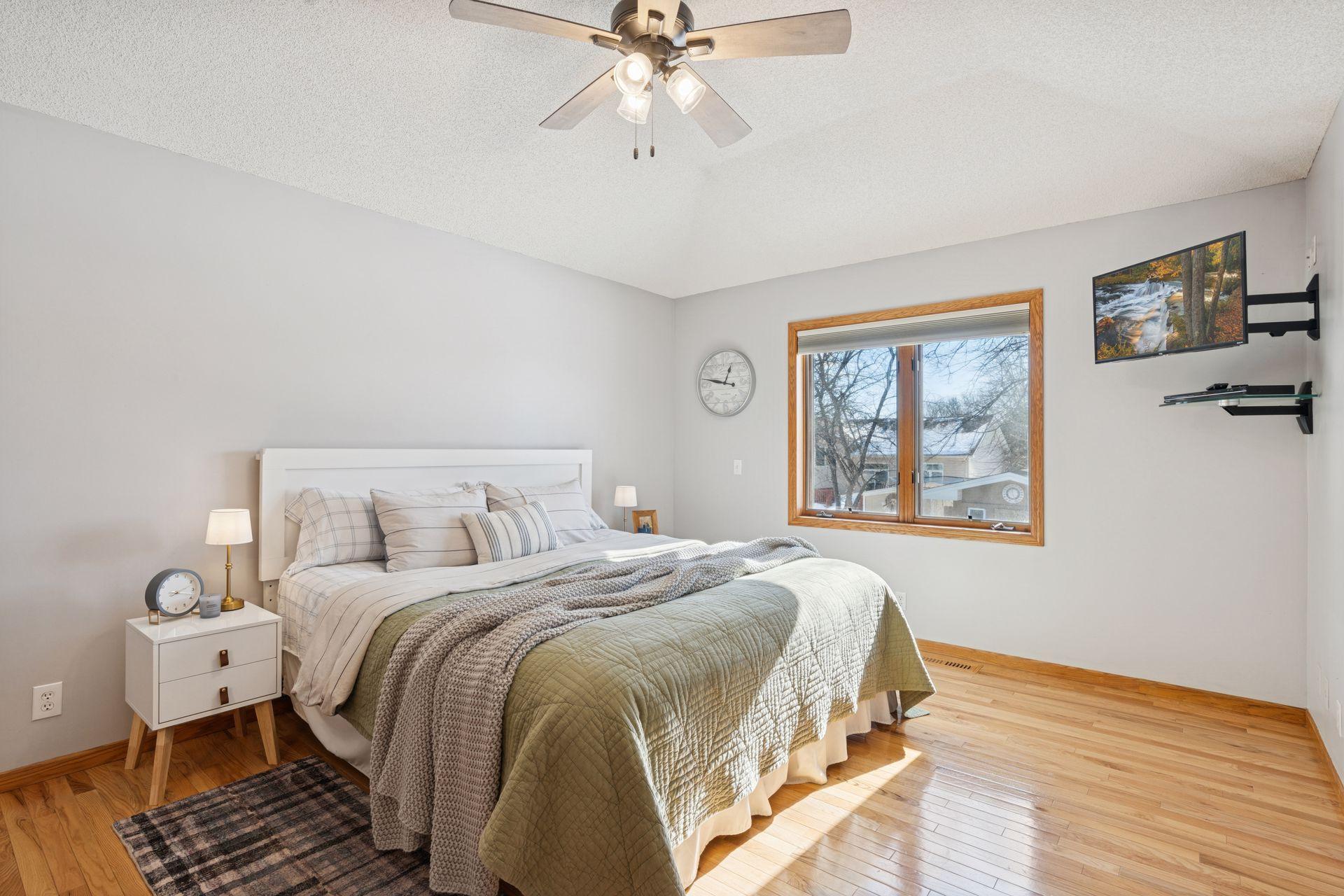 Large primary suite features hardwood floors and access to the private bath and oversized walk-in closet.