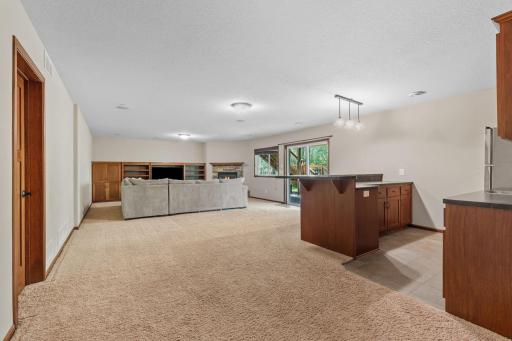 Spacious and inviting lower level designed for both relaxation and entertaining. This expansive basement features a cozy fireplace, custom built-ins, and a convenient wet barâperfect for movie nights, game days, or hosting guests.
