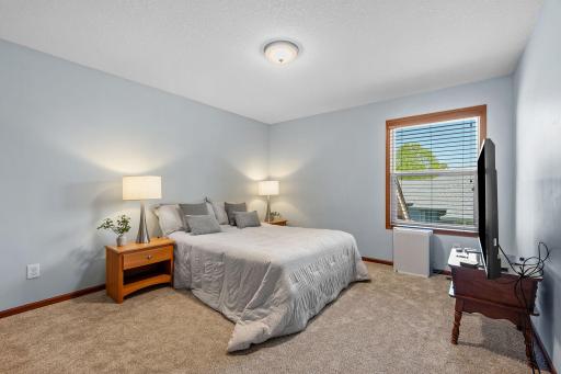 Bedroom located on upper level with new carpet and window overlooking side of home