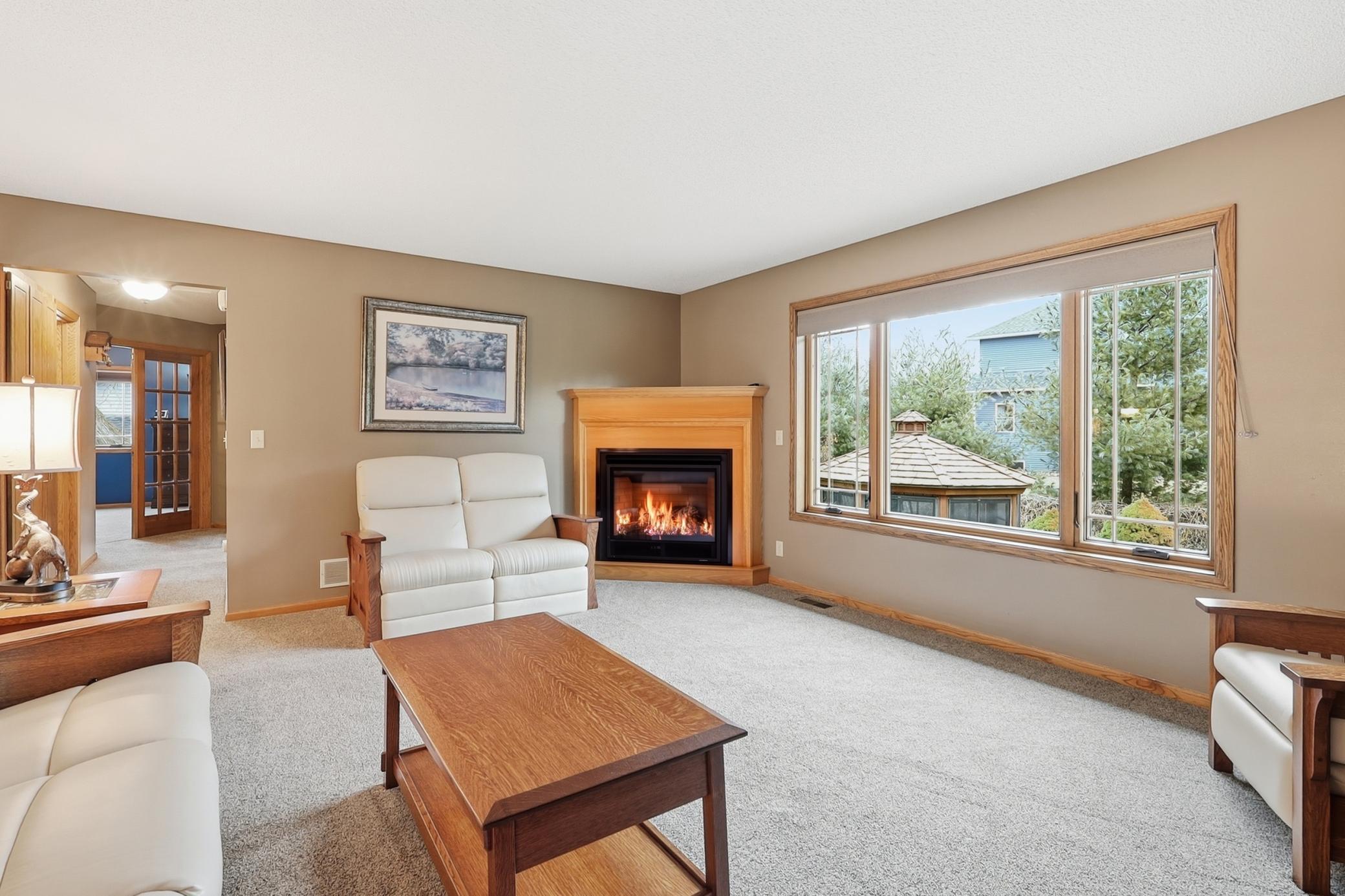 Enjoy a sun-filled living room with upgraded carpet and a cozy fireplace.