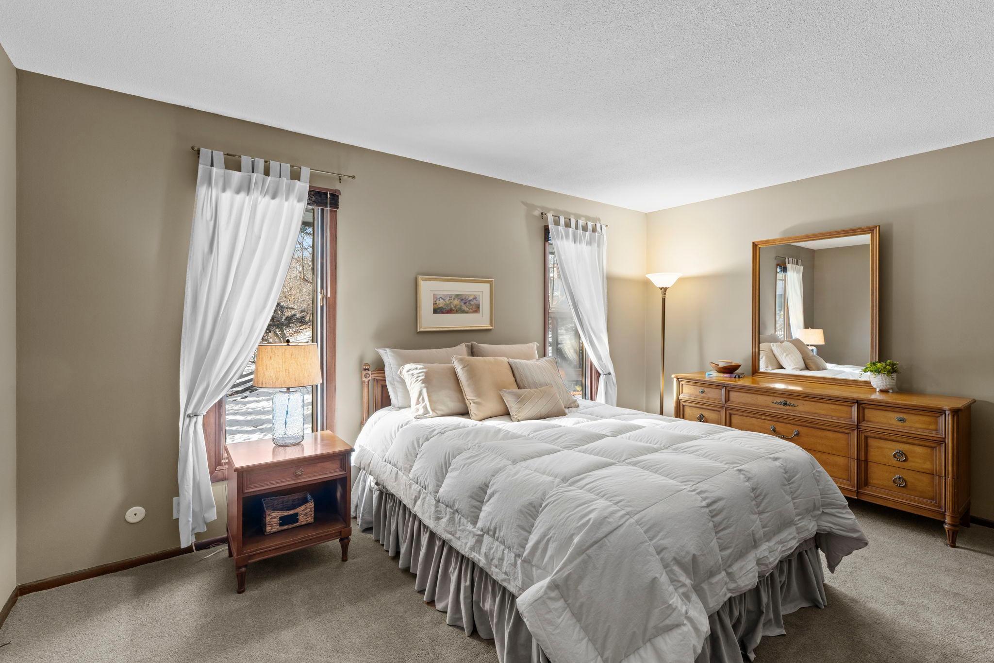Large primary bedroom with double windows, walk-through bathroom and spacious walk-in closet.