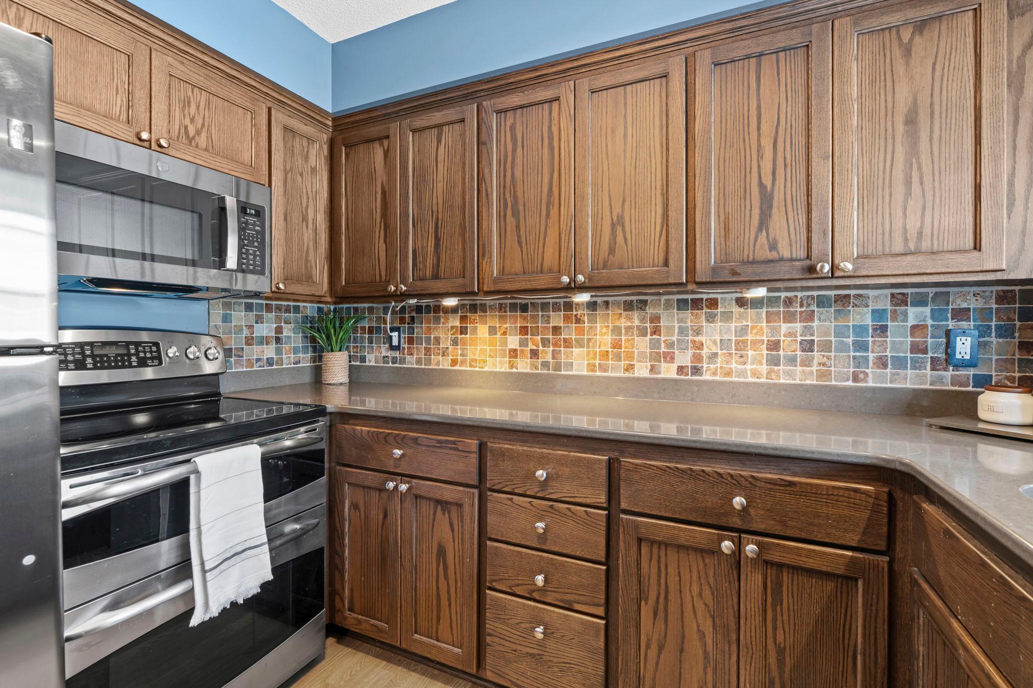 Modern, updated kitchen with Stainless Steel appliances, Cambria countertops and slate tiled backsplash.