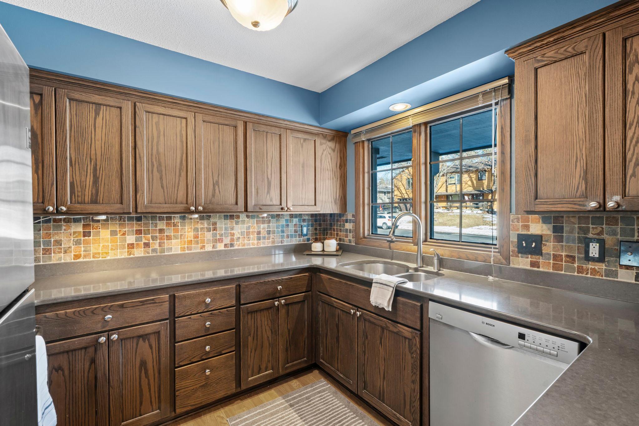 Modern, updated kitchen with Stainless Steel appliances, Cambria countertops and Slate tiled backsplash.