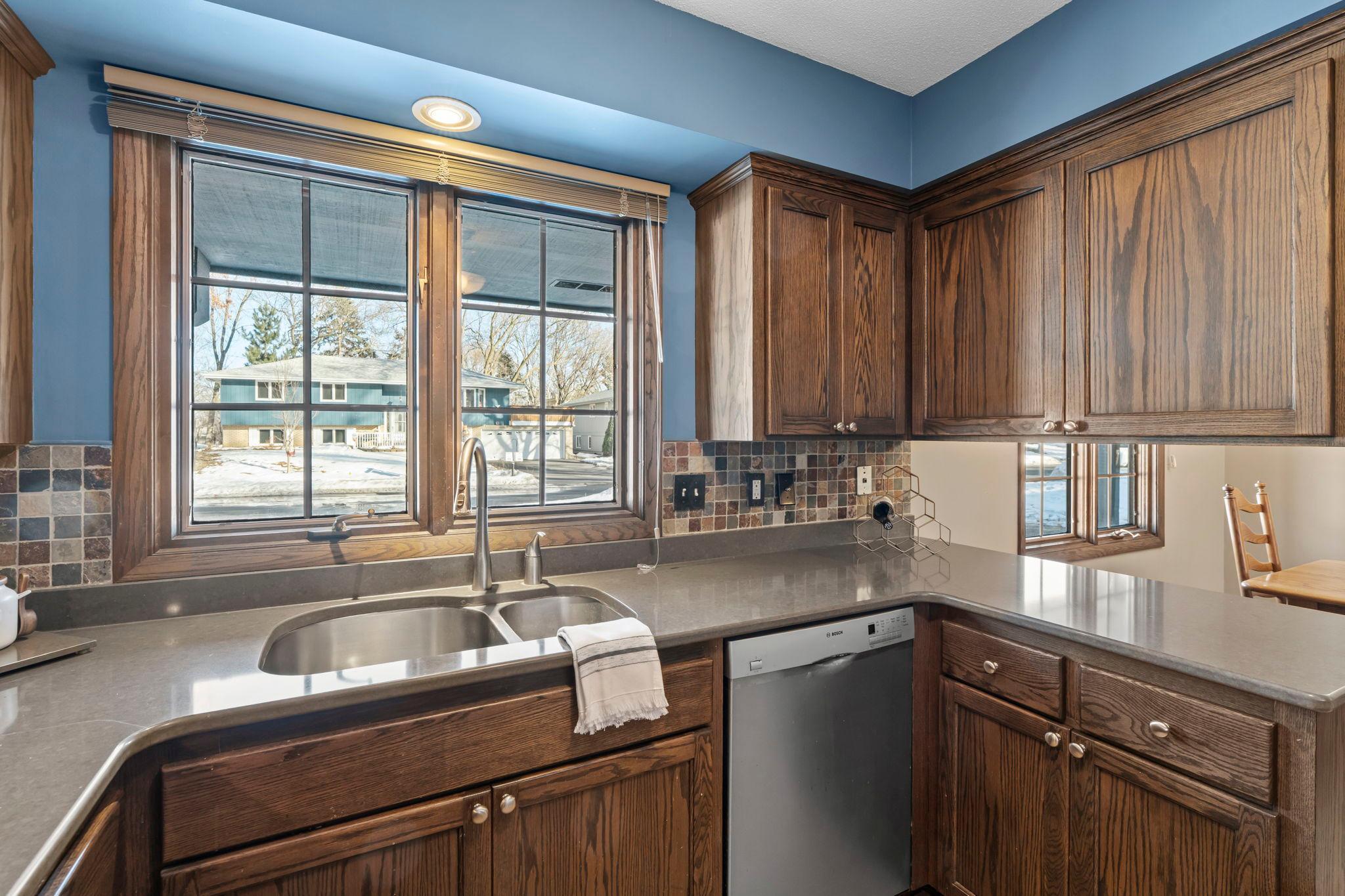 Modern, updated kitchen with Stainless Steel appliances, Cambria countertops and slate tiled backsplash.