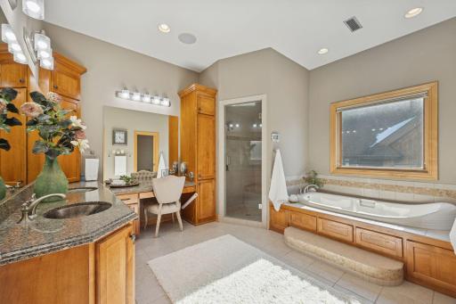 Luxurious primary bath featuring a soaking tub, walk-in steam shower,
