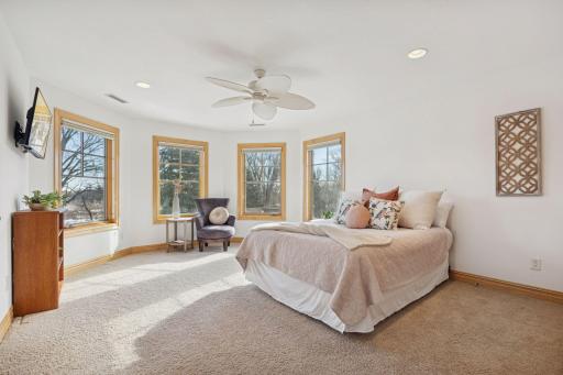 Bright upper-level bedroom with panoramic windows and a serene, airy feel.
