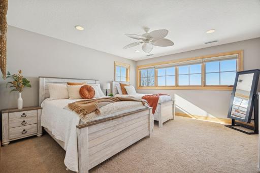 Sunny upper-level bedroom with warm natural light and a clean, relaxing layout.