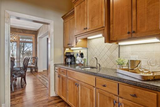 Charming butlerâs pantry featuring rich cabinetry, under-cabinet lighting, and a sleek prep area ideal for entertaining.