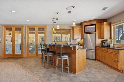 Stylish lower-level wet bar with stainless appliances, ample seating, and easy access to outdoor entertaining.
