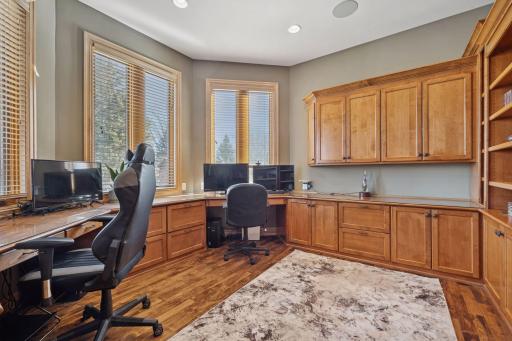 Bright, well-appointed home office with wraparound workspace and abundant built-in storage.