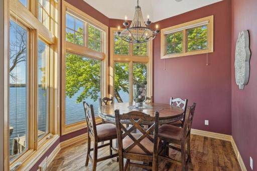 Sun-filled dining nook with panoramic windows and warm, inviting designâperfect for relaxed meals with a view.
