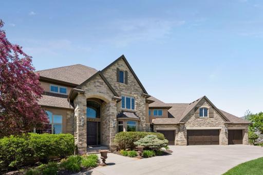 Attention to detail and stellar craftsmanship starts at the front of the house, with its stone facade and concrete driveway