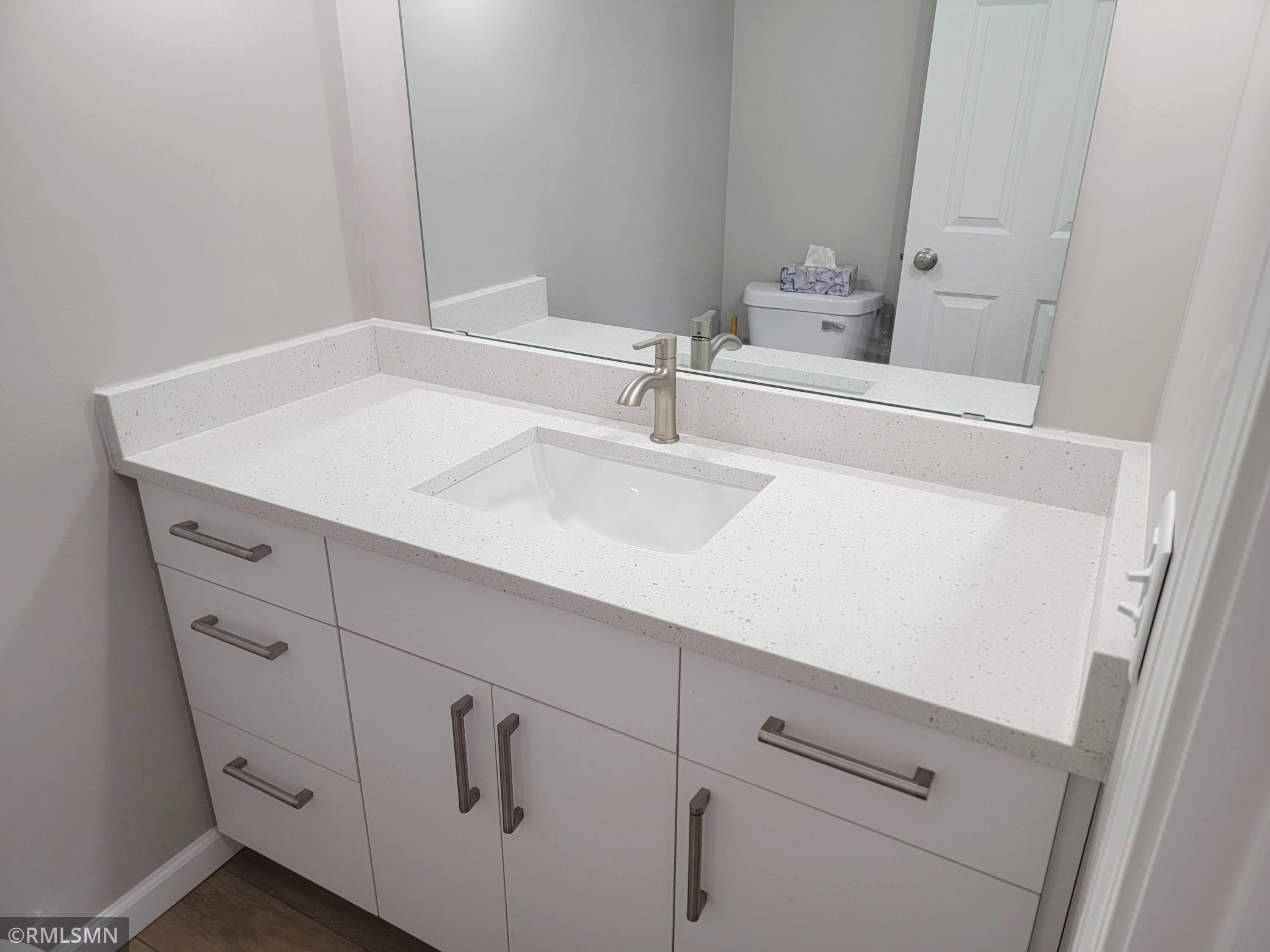 Primary bathroom vanity has quartz top