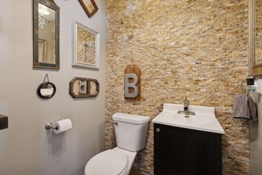 Main-level half bath with decorative stone accent.