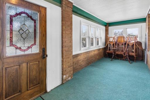 Front entryway porch - previously was an open porch space, original exterior brick is still exposed adding additional charm to the home