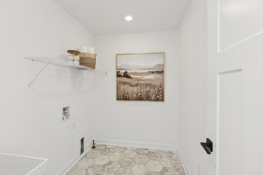 (Photo of actual model) The laundry room features a sink and shelving.