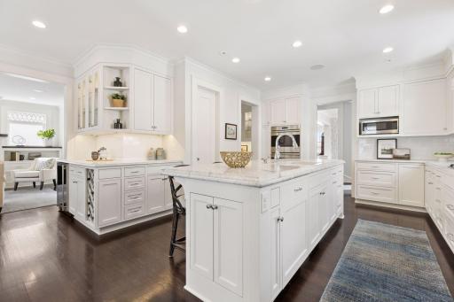 Chef's kitchen opens to formal living room, sitting room, side door entry and lower level