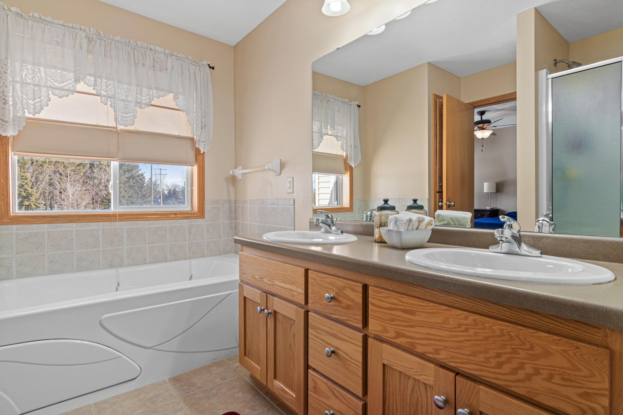 Primary bathroom with bathtub overlooking the backyard