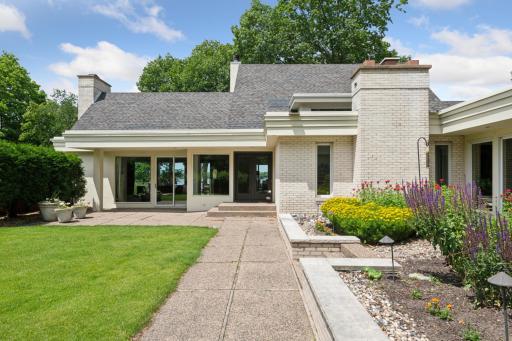 Guests are welcomed into a beautifully manicured courtyard as they approach the home