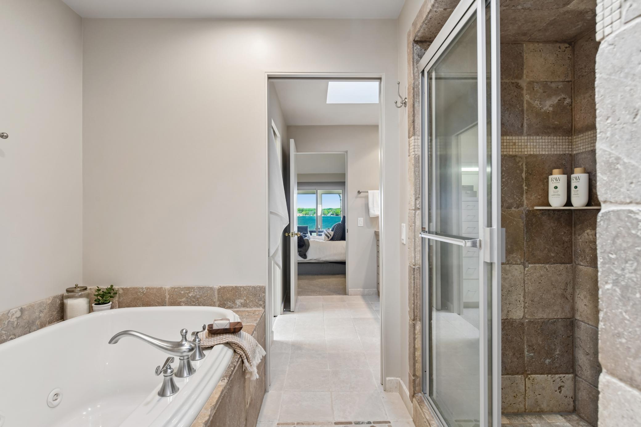 Heated tiles floors flow throughout the primary bath. The shower and bath showcase tile finishes with pocket doors to close off from each prospective powder room.