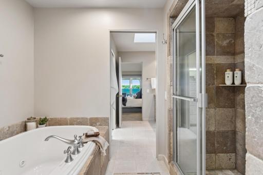 Heated tiles floors flow throughout the primary bath. The shower and bath showcase tile finishes with pocket doors to close off from each prospective powder room.